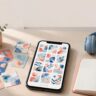 A smartphone with colorful flashcards beside study cards, headphones, and an open notebook.
