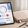A quiz tablet, French workbook, pen, coffee, and flag bookmark on a bright desk.