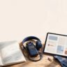 A notebook, tablet, headphones, and audio recorder sit beside lavender on a wooden desk.